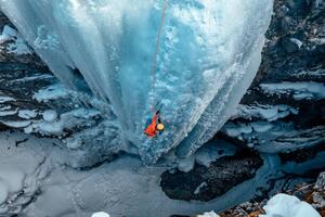 Fotografie de artă A woman ice climbs up a, Alex Ratson, (40 x 26.7 cm)