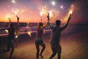 Fotografie de artă Friends running on a beach with fireworks, wundervisuals, (40 x 26.7 cm)