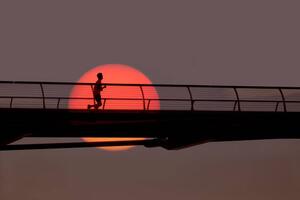 Fotografie Man out for morning run over bridge., Grant Faint, (40 x 26.7 cm)