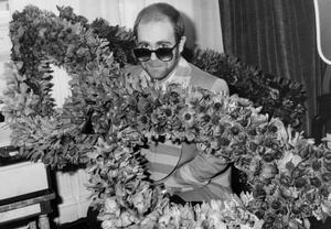 Fotografie English Singer Elton John at his Arrival in Paris : Bunch of Flowers in The Shape of Glasses He Wears, December 1St, 1976