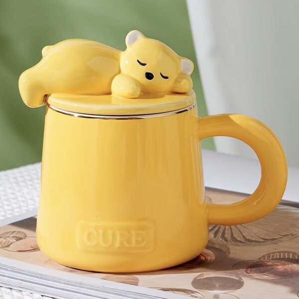 Cana cu capac din ceramica si lingurita Pufo Sleepy Bear pentru cafea sau ceai, 320 ml, galben