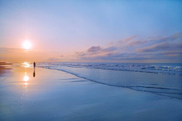 Fotografie de artă Person walking on beach at sunrise, Shannon Fagan, (40 x 26.7 cm)